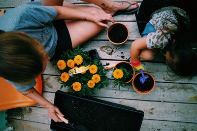 Directly above view of mother and daughter sitting on porch for gardening