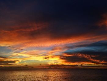 Scenic view of sea against dramatic sky during sunset