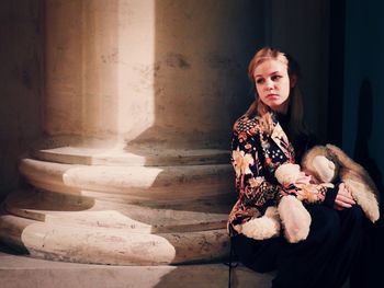 Portrait of young woman sitting on staircase