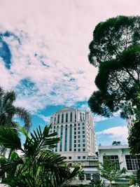 Low angle view of palm trees and building against sky