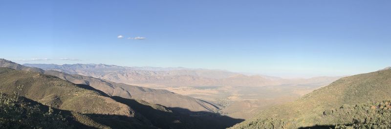 Scenic view of mountains against blue sky