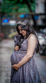 Young woman standing and seeing her pregnant tummy 