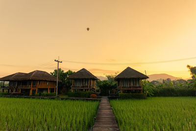 House on field against sky during sunset