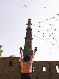 Rear view of birds flying against the sky