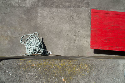 Directly above view of rope and red wooden plank by retaining wall