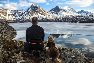 Rear view of man looking at view of snowcapped mountain