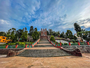 Staircase leading towards temple outside building against sky