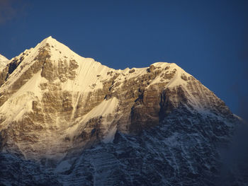 Scenic view of snowcapped mountains against clear blue sky