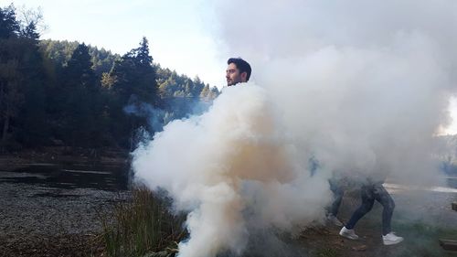 Man with smoke standing on land