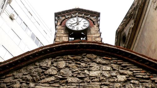 Low angle view of clock against sky