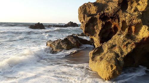 Rocks on beach against sky