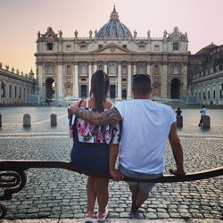 Rear view of man and woman against building