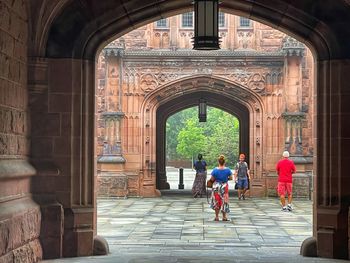 Rear view of people walking in historic building