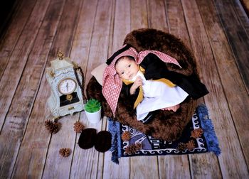 High angle view of girl sitting on wooden floor