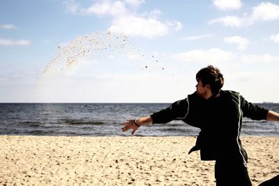 Man standing at beach against sky