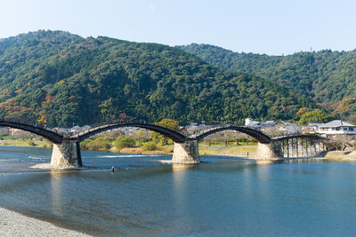 Bridge over river against mountain