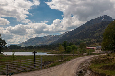 Road leading towards mountains against sky