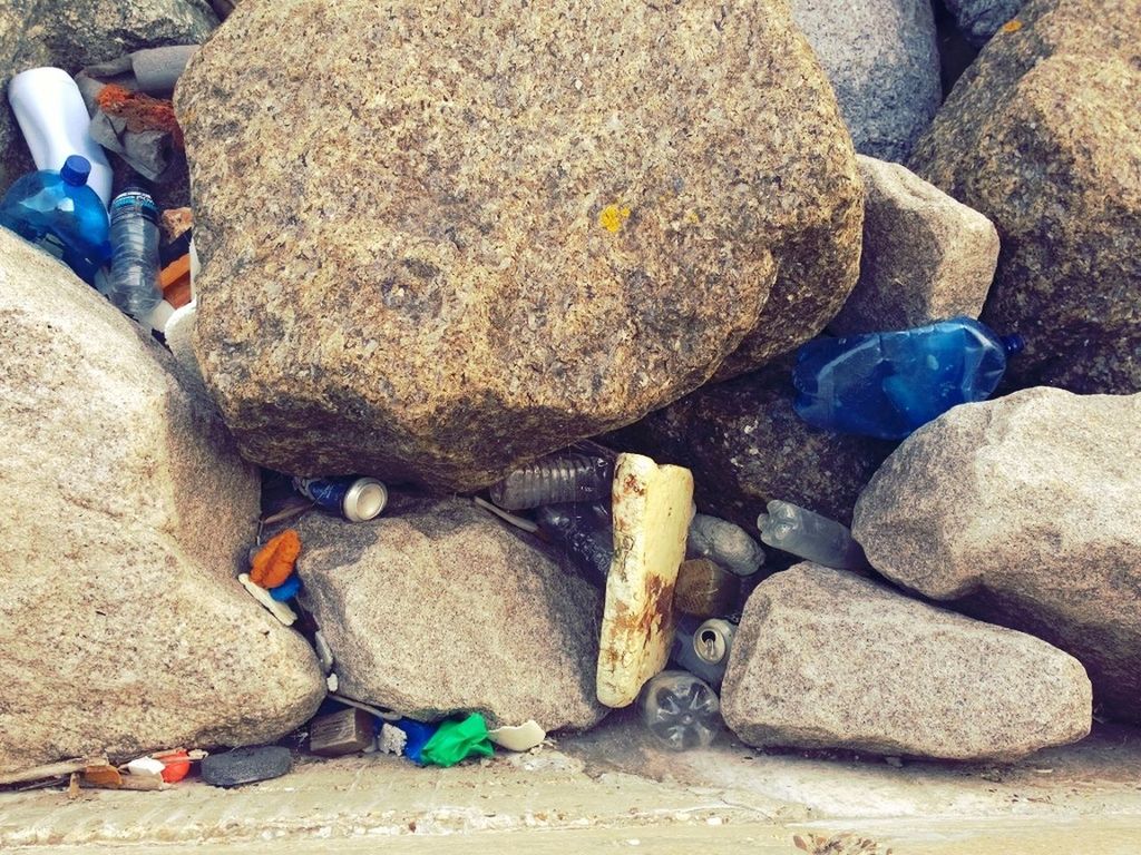 sand, beach, rock - object, stone - object, high angle view, sunlight, day, pebble, outdoors, blue, stone, shore, rock, abundance, nature, rock formation, textured, childhood