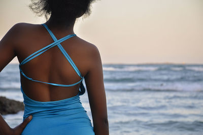 Rear view of woman standing at beach