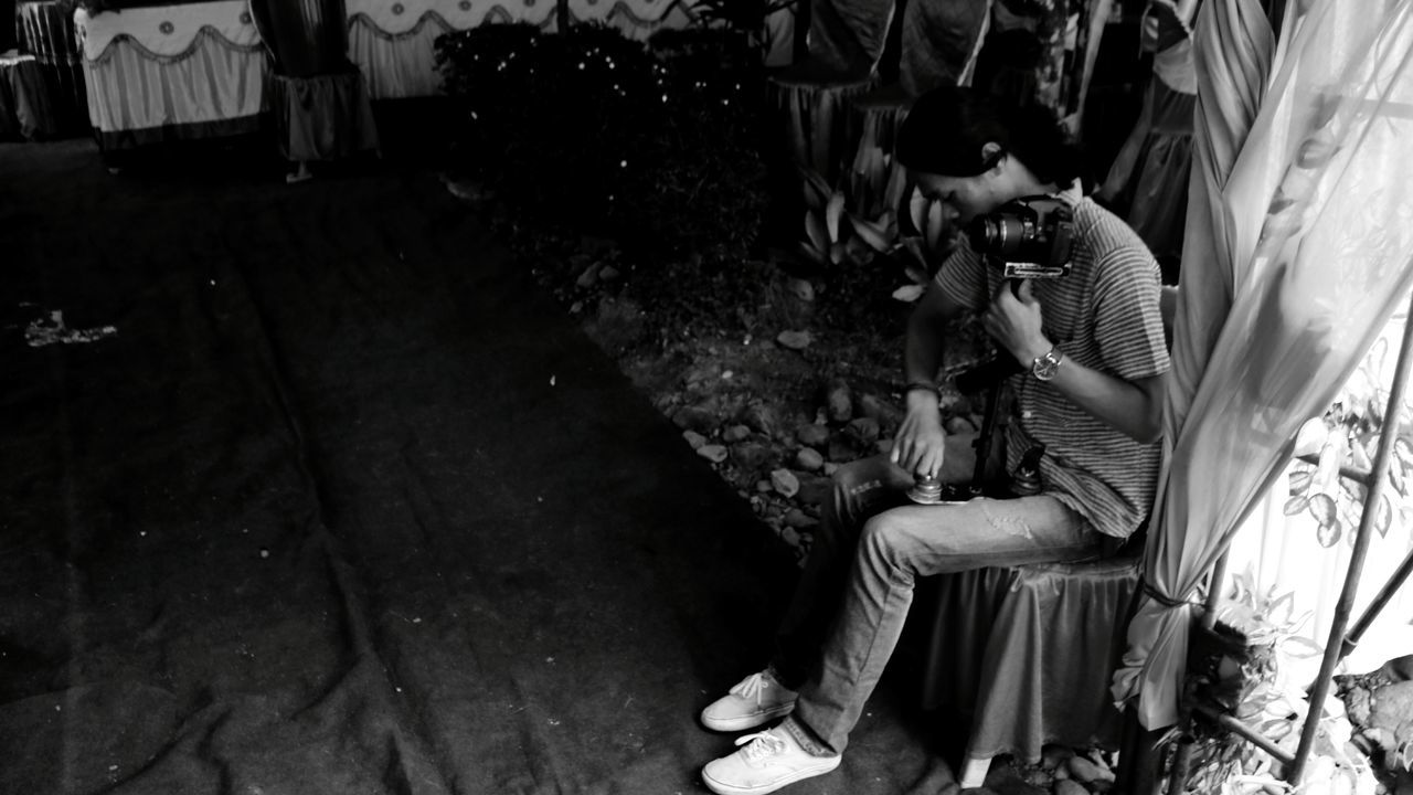 MIDSECTION OF WOMAN SITTING ON SIDEWALK