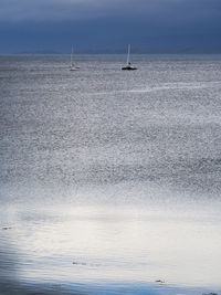 Sailboat sailing on sea against sky