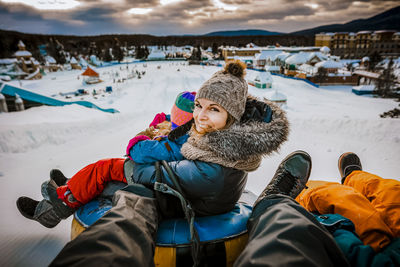 Mother sliding with her family on tubes during a winter day