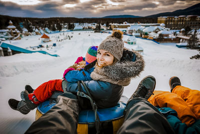 Mother sliding with her family on tubes during a winter day