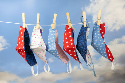 Low angle view of flags hanging on rope against sky