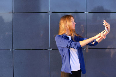 Rear view of woman standing against wall