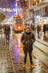 Rear view of man walking on street at night