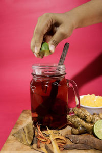 Close-up of hand holding glass jar on table