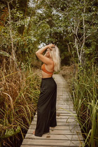 Rear view of woman standing against plants