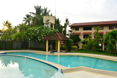 Swimming pool by building against sky