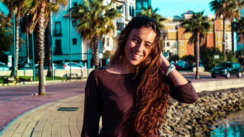 Smiling young woman with palm tree