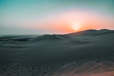 Scenic view of desert against sky during sunset