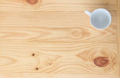 Directly above shot of coffee cup on wooden table