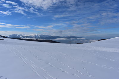 Snow covered landscape against sky