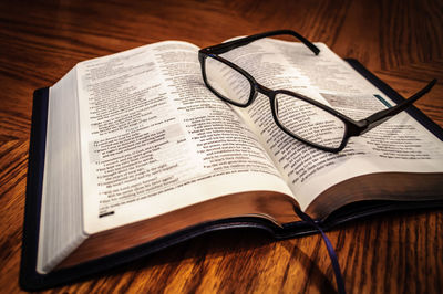 Close-up of bible and eyeglasses on table