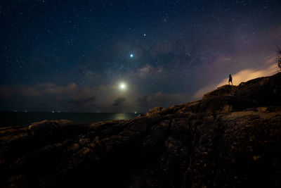 Lonely man standing confront to milky way in night sky