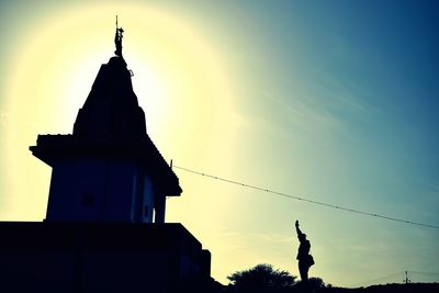 Low angle view of silhouette statue against sky at sunset