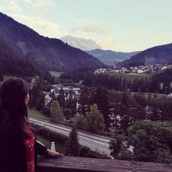 Rear view of woman standing on mountain against sky