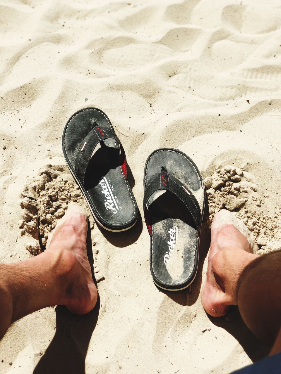 human body part, real people, land, sand, men, personal perspective, body part, leisure activity, low section, lifestyles, shoe, beach, day, sunlight, human hand, nature, people, unrecognizable person, human leg, hand, outdoors, human foot, slipper, finger