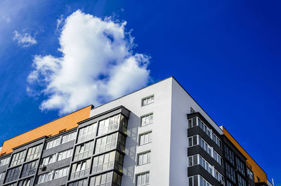 Apartment building on background of blue sky with clouds