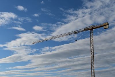 Low angle view of crane against sky