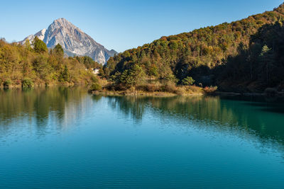 Scenic view of lake by mountains against sky