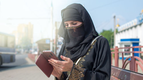 Rear view of woman using mobile phone