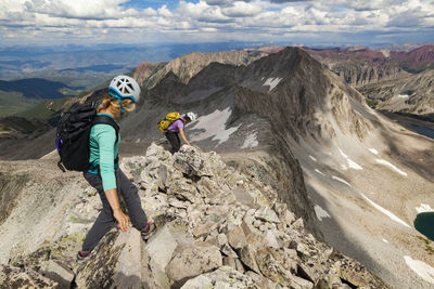 Women descend ridge on capitol peak, elk mountains, colorado