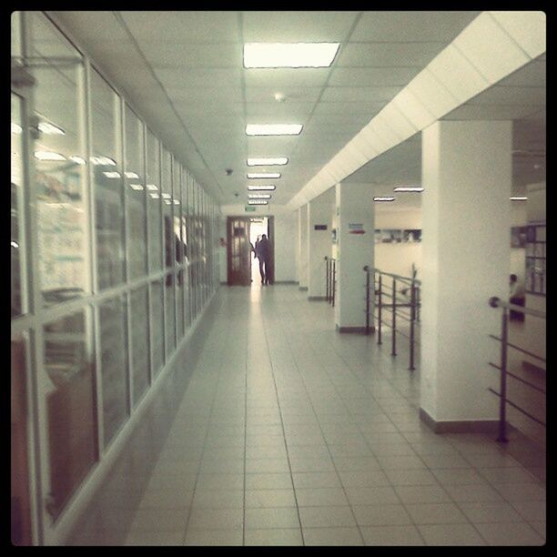 indoors, corridor, architecture, built structure, tiled floor, ceiling, flooring, the way forward, empty, diminishing perspective, illuminated, modern, architectural column, transfer print, tile, incidental people, in a row, subway, absence, subway station