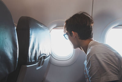 Rear view of woman looking through window