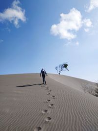 Full length of man walking on sand dune